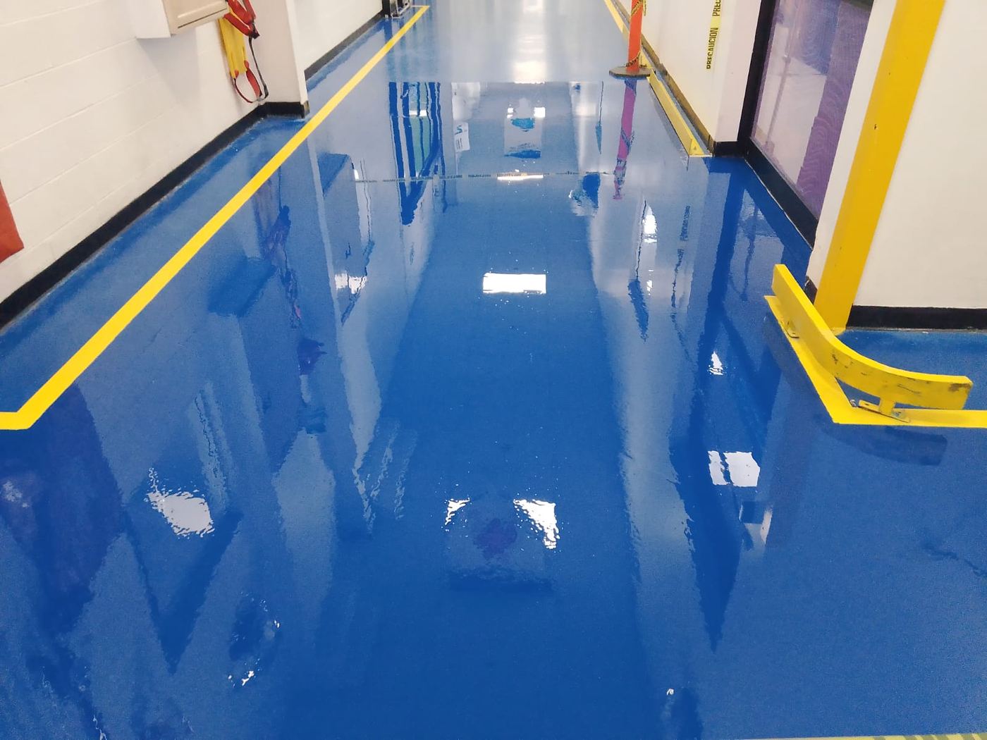 Pasillo de epóxico azul con señalización